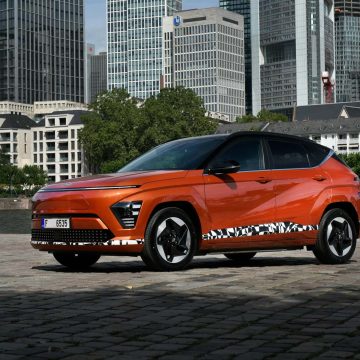 Hyundai Kona Elektro in orange von schräg vorne.