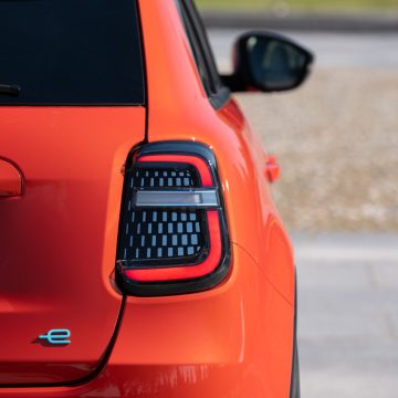 'e'-Plakette am Heck des des Fiat 600e La Prima in Orange Sun of Italy.