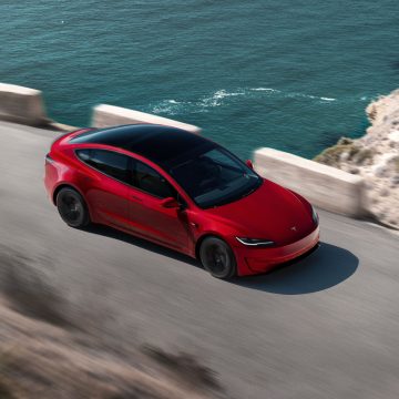 Tesla Model 3 Performance in Ultra Red von schräg oben bei der fahrt
