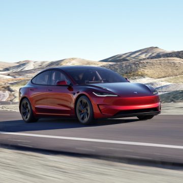 Tesla Model 3 Performance in Ultra Red von schräg vorne bei der Fahrt